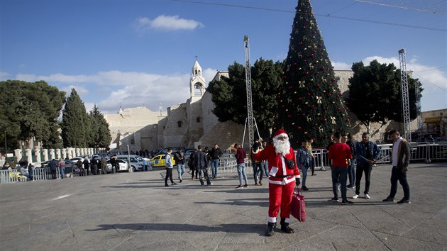 Palestinec v kostmu Santa Klause vt kesansk nvtvnky ped kostelem Narozen Pn v Betlm. (5. prosince 2019)