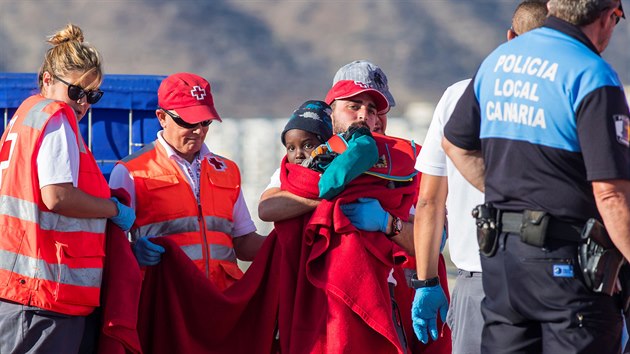 Migranti zadren u pobe ostrova Gran Canaria nastupuj na panlskou zchrannou lo. (18. prosince 2019)