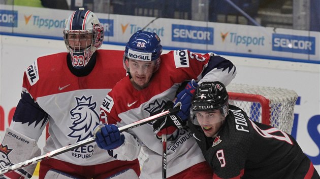 Český junior Šimon Kubíček (uprostřed) v souboji s kanadským reprezentantem Liamem Foudym. V pozadí brankář Lukáš Pařík.