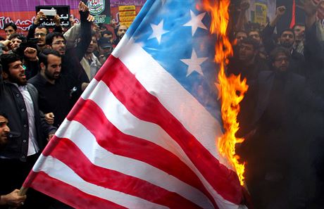 Zfanatizovaný dav pi protestech v Íránu tradin pálí vlajku USA.