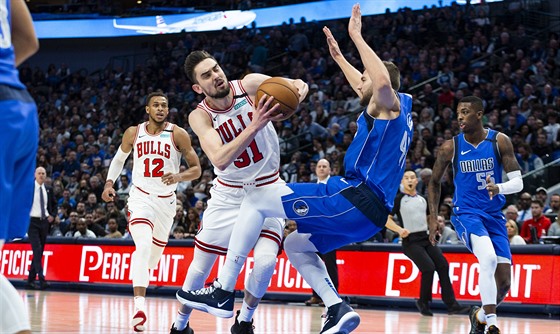 Tomá Satoranský z Chicaga se probíjí pod ko, proti nmu Maxi Kleber z Dallasu.