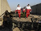 Záchranái odnáejí tlo obti pádu letadla ukrajinských aerolinek, které se...
