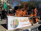 Palestintí píznivci Hamasu pálí model rakve symbolizující americké...