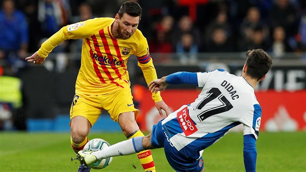 Lionel Messi z FC Barcelona se probj pes Didace Vilu z Espaolu.