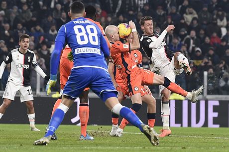 Daniele Rugani z Juventusu stílí pes bránící hráe Udine.