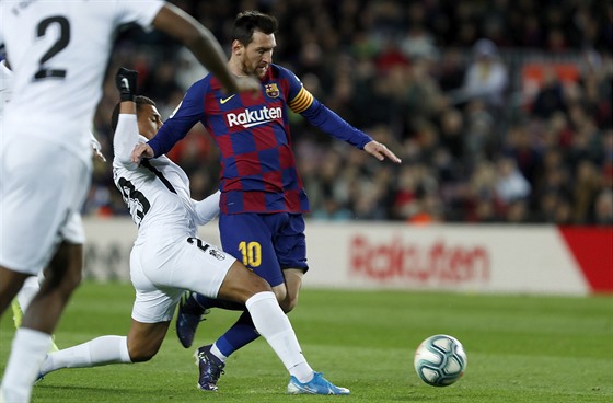 Lionel Messi z Barcelony (ve tmavém) bí za balonem, zastavit se ho snaí...