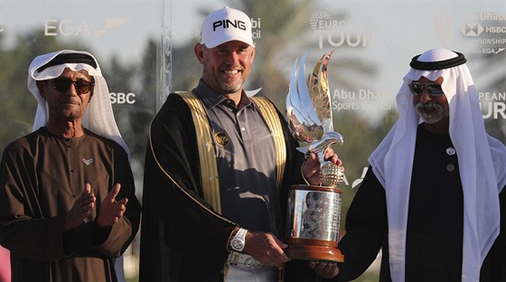 Anglický golfista Lee Westwood (uprostřed) s trofejí pro vítěze turnaje v Abú...