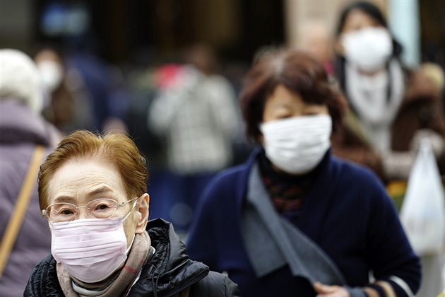 Lidé s respiraními roukami v Tokiu. Japonská vláda informovala o úmrtí mue,...