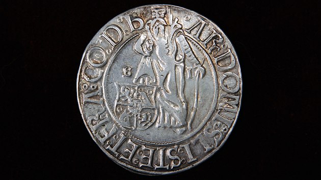 Originál jáchymovského tolaru z roku 1520. Na aversu je sv. Jáchym, ochránce důlní oblasti, označený písmeny S a I po jeho pravé a levé straně, pod svou pravou nohou má šlikovský erb.