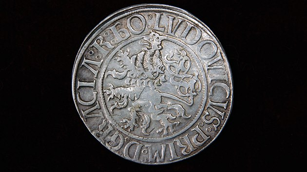 Originál jáchymovského tolaru z roku 1520. Na reversu je český zemský znak s dvouocasým lvem, v opise latinsky jméno a titul panovníka - Ludvík I., z Boží milosti král český.