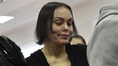 Obviněná Alena Zsuzsová přichází v doprovodu stráže do jednací síně...