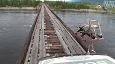 A jet jeden zábr na nebezpený most pes eku Vitim v Rusku.