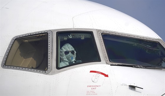 Pilot nákladního letadla na letišti ve Wu-chanu oblečený do ochranných pomůcek....