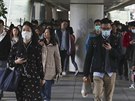 Lidé v Hongkongu procházející ulicemi Hongkongu si obliej chrání roukami....
