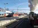 Vlak s parní lokomotivou 213 902 na nádraí Praha-Hostiva míjí motorovou...