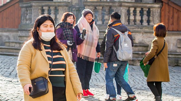 N�kte�� asij�t� turist� si p�i prohl�dce �esk�ho Krumlova chr�n� obli�ej rou�kou. (17. ��jna 2019)