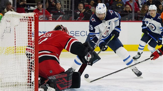 Brank Caroliny Petr Mrzek ve stehu, proti nmu  Blake Wheeler z Winnipegu.