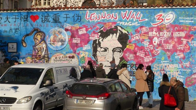 Turisté píší vzkazy fixem na Lennonovu zeď. Sprejování je zakázáno, ale někteří to stále nedodržují.. (27.1.2020)