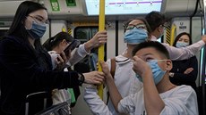 Cestující v hongkongském metru s nasazenými respiraními roukami. (24. ledna...