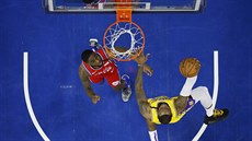 LeBron James z Los Angeles Lakers zakončuje, pod košem přihlíží Shake Milton z...