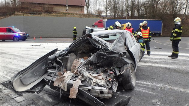 Pi nehod t aut na silnici I/33 ped Nchodem hasii odstraovali z vozovky rozlit elektrolyt a rozsypanou mouku (30. 1. 2020).