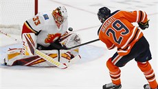 David Rittich (33) z Calgary zasahuje proti stele Leona Draisaitla z Edmontonu.