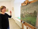 Průvodkyně Jarmila Krejčová ukazuje obraz Farských humen od Jaroslava Švomy....