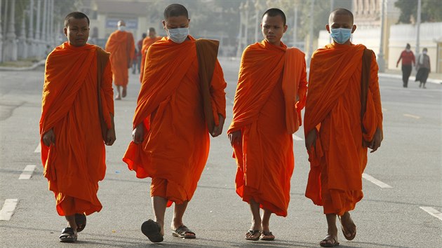 Buddhistit mnii s respiranmi roukami v ulicch Phnompenhu v Kambode. (28. ledna 2020)