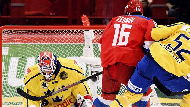 Rusk hokejista Denis Zernov v anci ped vdskm glmanem Larsem Johanssonem.