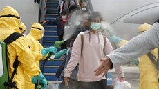 Indonétí zdravotníci dezinfikují lidi evakuované z ínského Wu-chanu, odkud se...