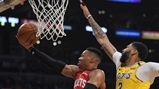 Russell Westbrook z Houstonu zakonuje na ko LA Lakers. Brání ho Anthony Davis.