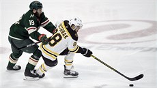 Luke Kunin z Minnesoty stíhá Davida Pastráka z Bostonu.