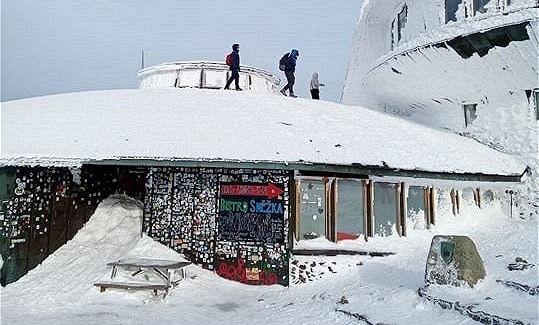 Turisté lezou na stechu meteostanice na Snce.