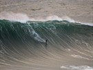 Surfa sjídjící vlnu v portugalském Nazaré. (20. listopadu 2019)