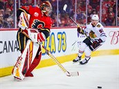 Brank Calgary David Rittich kontroluje puk v duelu s Chicagem.