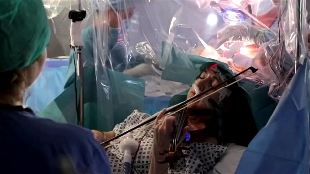 Žena hraje na housle během operace mozku