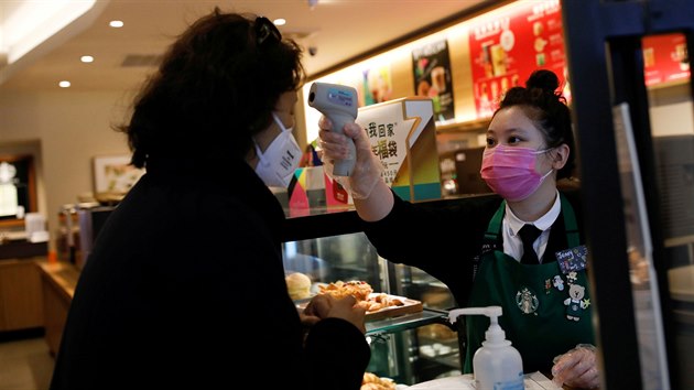 Zamstnankyn kavrny Starbucks v Pekingu m nov pchoz zkaznici teplotu. (16. nora 2020)