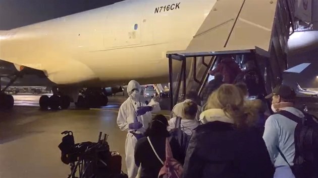 Amerit pasai evakuovan z vletn lodi Diamond Princess nastupuj do specilnho letadla, kter je vezme zpt do USA. Lo se nachz v karantn v Japonsku kvli nkaze koronavirem. (16. nora 2020)