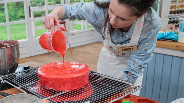 Soutěžící Anička a její maximální soustředění při polévání zmrzlého dortu lesklou polevou.