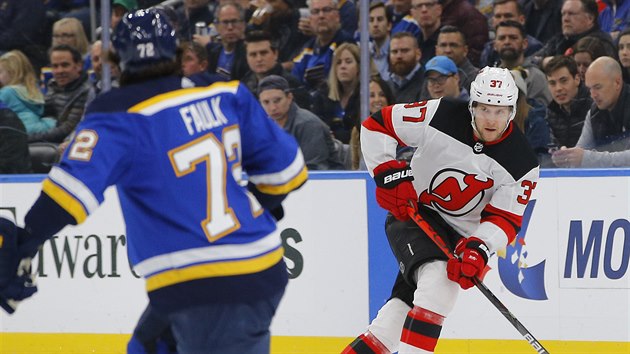 Pavel Zacha z New Jersey hled pihrvkou spoluhre, sleduje ho Justin Faulk ze St. Louis.