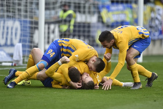 Opavští fotbalisté se radují z branky na zádech ležícího Reného Dediče.