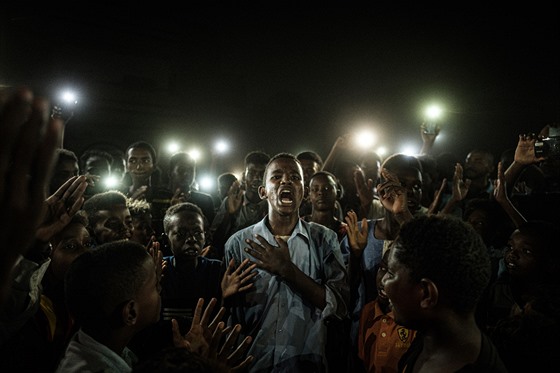 FOTOGRAFIE ROKU: Jasujoši Čiba, AFP; Mladý Súdánec osvětlený mobilními telefony při projevu k demonstrantům