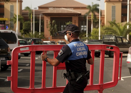 Španělský policista staví blokádu před hotelem v letovisku Adeje na jihu...