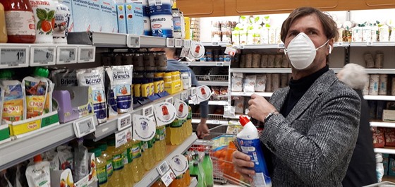 Muž s respirátorem nakupuje zásoby. (23. února 2020)