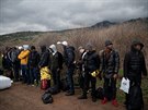 Skupina uprchlík ze subsaharských zemí stojí na plái poté, co dorazila na...