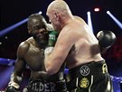 Tyson Fury (vpravo) a Deontay Wilder v boji o pás mistra svta tké váhy...