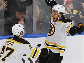 Torey Krug (47) a David Pastrňák slaví vítězný gól Bostonu proti Edmontonu.
