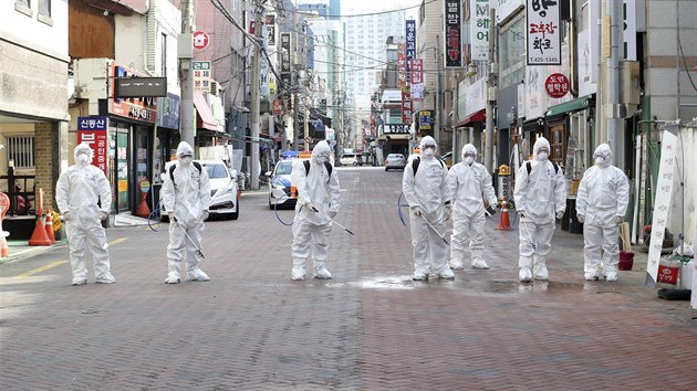 Jihokorejští vojáci v ochranných oděvech preventivně dezinfikují ulice v Soulu. V zemi je už 1595 nakažených novým koronavirem. (27. února 2020)