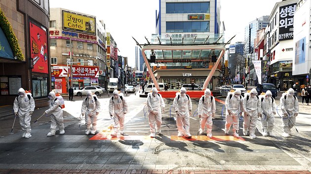 Jihokorejští vojáci v ochranných oblecích preventivně dezinfikují ulice Tegu, které je v zemi největším ohniskem nákazy koronaviru. (27. února 2020)