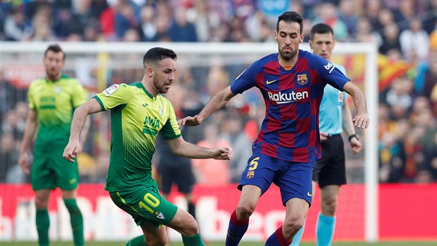 Edu Expsito z Eibaru (vlevo) a Sergio Busquets z Barcelony bojuj o balon.